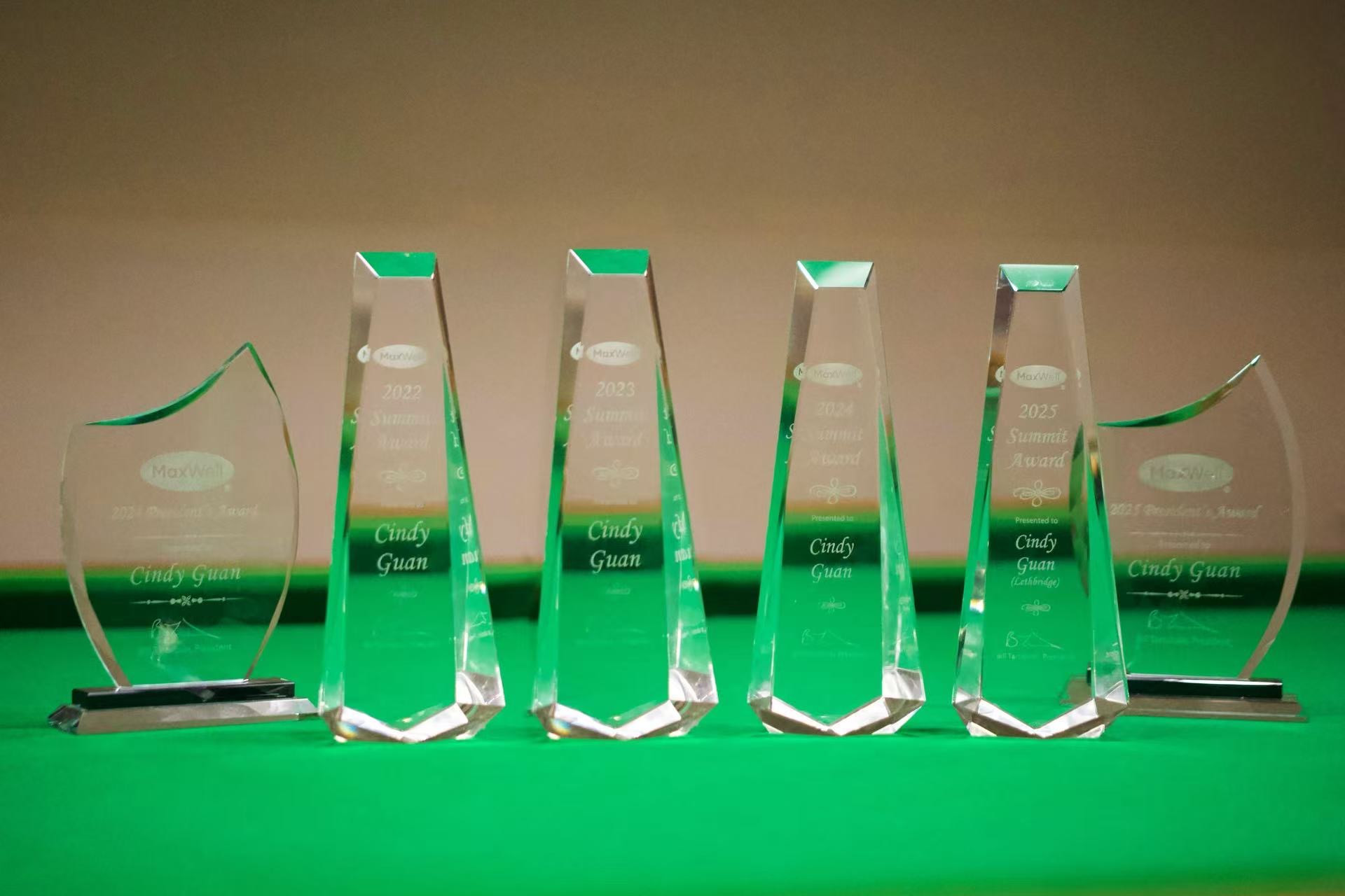 Original photograph of Cindy Guan’s professional awards, including MaxWell Summit Awards 2022–2025
